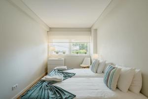 a bedroom with a large bed with pillows on it at Villa Miramar - Seaside Cascais in Cascais