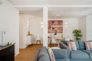 a living room with a blue couch and a dining room at Villa Miramar - Seaside Cascais in Cascais