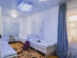 a room with two beds and a chandelier at Naryn Cozy House in Naryn