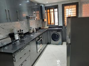 a kitchen with a washer and a washing machine at Appartement de luxe Haut Founty in Agadir