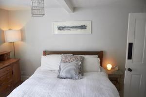a bedroom with a bed with a pillow on it at Earl Cottage, Woodbridge in Woodbridge