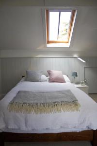 a bedroom with a large bed with a window at Earl Cottage, Woodbridge in Woodbridge