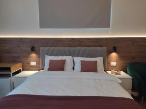 a bedroom with a large white bed with two pillows at Pyrus Apartments in Mojkovac