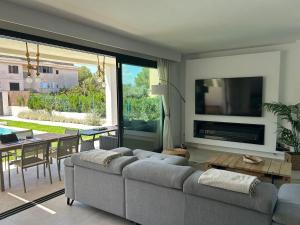 ein Wohnzimmer mit Couch und großem Fenster in der Unterkunft Luxury house in Puerto Alcudia in Alcúdia