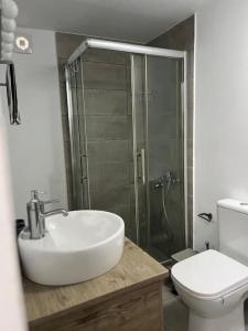 a bathroom with a sink and a shower and a toilet at Seaside Lavrio Beach House in Sounio