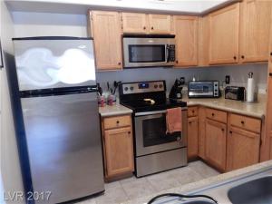 a kitchen with stainless steel appliances and wooden cabinets at Southwest Retreat - Stylish Room with Queen Bed, Fast Wi-Fi & More! in Las Vegas