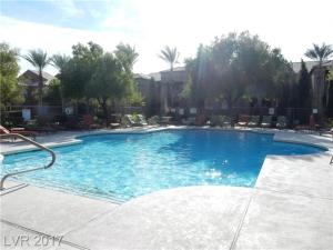 a large blue swimming pool with chairs and trees at Southwest Retreat - Stylish Room with Queen Bed, Fast Wi-Fi & More! in Las Vegas