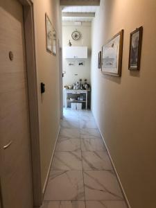 a hallway with a tile floor and a hallway with paintings on the walls at Gli Alloggi De Il Piccolo Borgo in Castel Maggiore +36 photos
