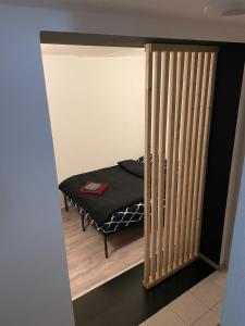 Una cama pequeña en una habitación pequeña con una partición. en European District Apartment Zero, en Bruselas