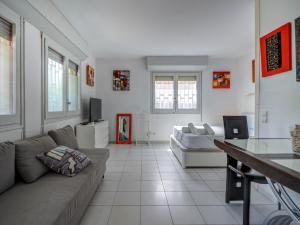 a living room with a couch and a tv at Los Globos Beach Studio by Hello Homes Sitges in Sitges