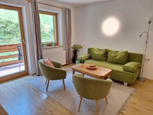 a living room with a green couch and a table at Apartments Weißstein in Gries im Sellrain