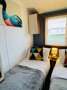 a small room with two beds and a duck on the wall at Place2bee , Caravan , Manor park , Free Wifi ,6 Berth in Hunstanton