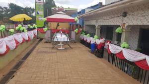 a street with a table and a fence with pink and green decorations at Famko Hotel Lira- Uganda in Lira