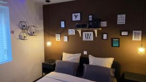 a bedroom with a bed and a wall with pictures at ARKANA, appartement avec 2 places de parking in Dole