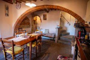 a kitchen with a wooden table and an archway at Appartamento rustico con vista in Montelupo Fiorentino