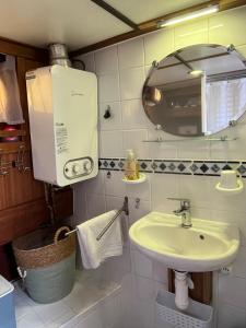 a small bathroom with a sink and a mirror at Spicy - Séjour insolite sur la Marne in Meaux