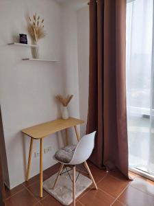 a desk and a chair in a room with a window at Chill Spot Staycation in Pasig in Manila