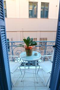 a table and chairs on a balcony with a potted plant at Preveza Palazzo in Preveza