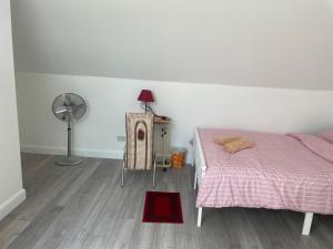 a bedroom with a bed and a fan and a red rug at OYO Baraka Edgware in Stone Grove +21 photos