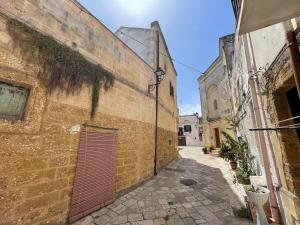an alley in an old building with a red door at La Meridiana Antica Residenza in Mesagne +27 photos