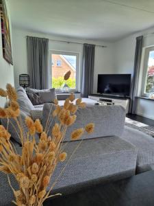 a living room with a couch and a tv at De Eekhoorn in Tzummarum +3 photos