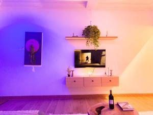 a living room with a purple wall and a dresser at Bohemian Suite in Accra +10 photos