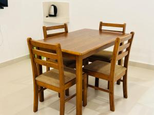 a wooden table with two chairs and a wooden table and chairsktop at Gamodh Citadel Resort in Anuradhapura