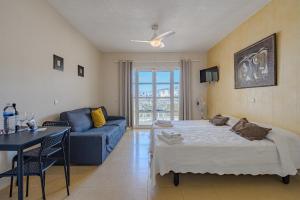 阿德耶Apartamentos ORLANDO en Costa Adeje的客厅配有床和蓝色沙发