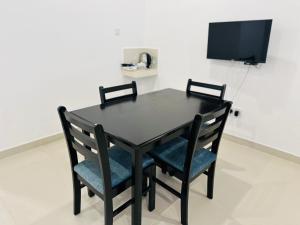 a black table with two chairs and a tv at Gamodh Citadel Resort in Anuradhapura