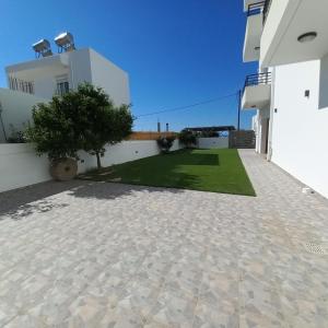a view of the courtyard of a house with a lawn at Central Rooms in Makry Gialos
