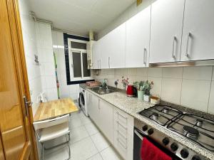 a kitchen with white cabinets and a sink and a stove at Rooms Argo in Barcelona +20 photos