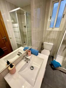 a white bathroom with a sink and a toilet at Rooms Argo in Barcelona