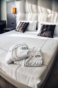 ミラノにあるAcca Palace AA Hotelsのベッドルーム1室(ベッド1台にタオル2枚付)