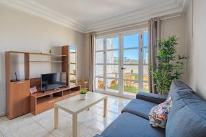 阿德耶Apartamentos ORLANDO en Costa Adeje的客厅里有一张蓝色沙发和一台电视