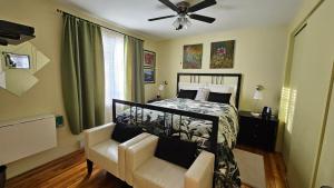 a bedroom with a bed and a chair and a ceiling fan at Gite Confort in Quebec City