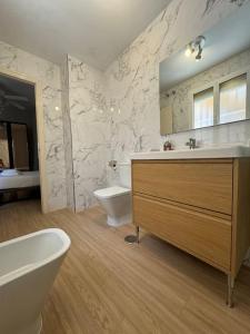 a bathroom with a sink and a tub and a toilet at Apartamento en San Bernardo, el barrio torero in Seville