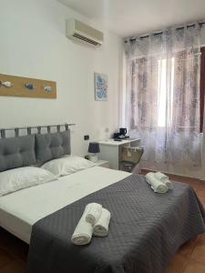 a bedroom with a bed with two towels on it at Il Canarino affittacamere in La Caletta
