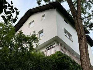 a large white building with a balcony and trees at Apartman Heli Meli 1 in Jajce +14 photos