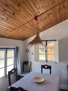 a table and chairs in a room with a wooden ceiling at Alentempo in Aldeia de Brescos +49 photos