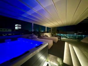a living room with a couch and a swimming pool at BlueMotion - CityView in Piraeus