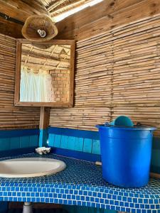 a bathroom with a large blue bucket on a counter at Hôtel Safari Vezo Anakao in Anakao