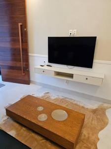 un soggiorno con una TV a schermo piatto su una parete di Casa Ideal e Confortável a Sinop