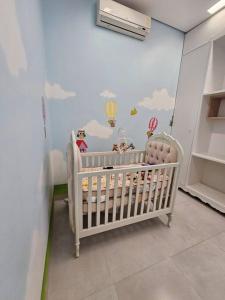 a baby room with a crib and a wall with clouds at Casa Ideal e Confortável in Sinop +26 photos
