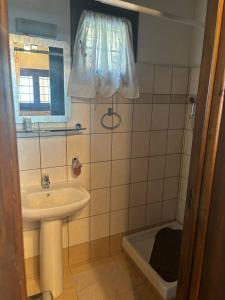 un piccolo bagno con lavandino e finestra di Οξυγόνο Πέτρινο εξοχικό στη Βυζίτσα Πηλίου a Vizitsa Altre 22 foto