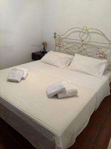 un letto bianco con due asciugamani sopra di Οξυγόνο Πέτρινο εξοχικό στη Βυζίτσα Πηλίου a Vizitsa