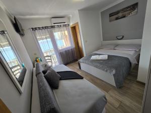 a small bedroom with two beds and a window at Guest House Berto in Crikvenica