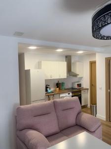 a living room with a couch and a kitchen at Apartamentos ANDASOL in Chipiona