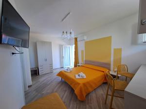a room with a bed and a table and a television at I Sette Ulivi Bed and Breakfast in Tergu