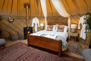a bedroom with a bed in a tent at Yurtshire Eavestone Lake - Willow in Ripon