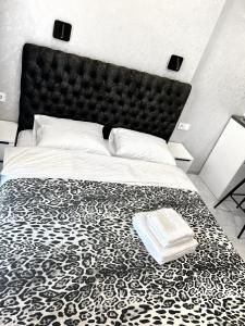 a bedroom with a large bed with a black and white blanket at VEM Apartment Калипсо in Odesa